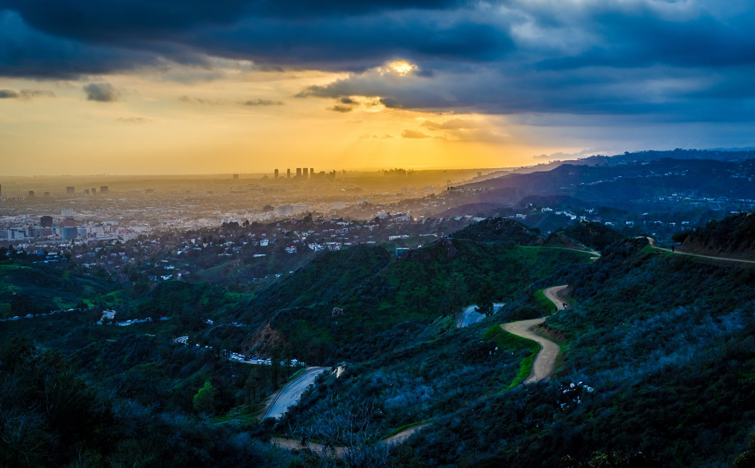 Wide view of an inhabited valley as the sun sets.