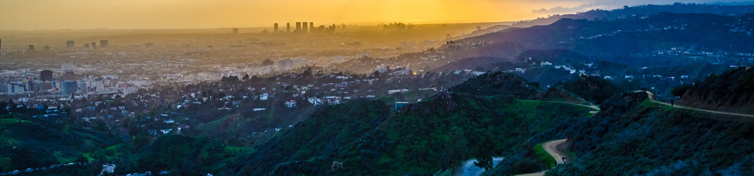 Wide view of an inhabited valley as the sun sets.