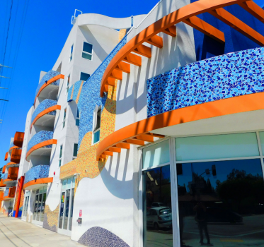 Colorful building with blue and orange accent highlights on top of a white building