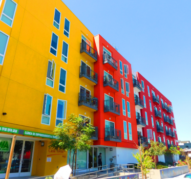 A tall colorful yellow and red residential building 